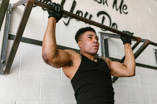 Close up of strong male hands griping a pull-up bar firmly