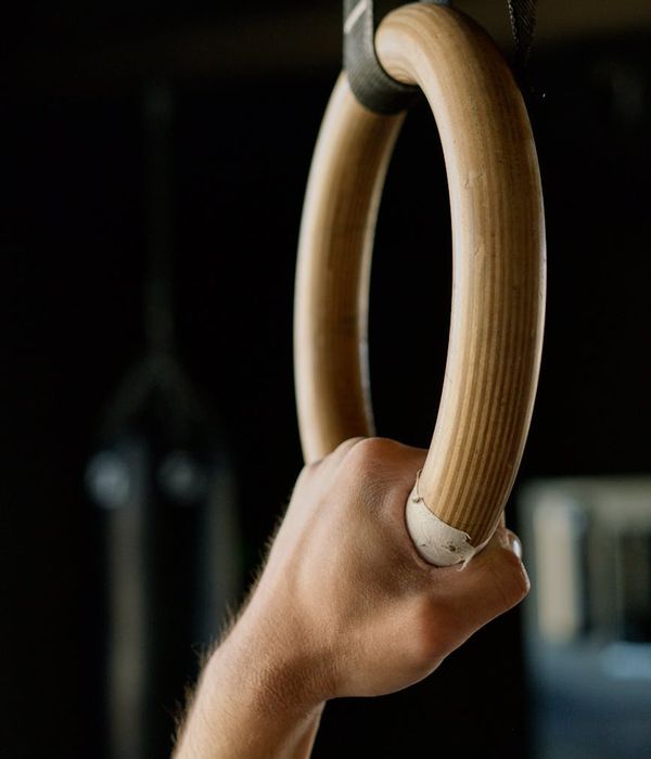 Determined man performing a controlled functional strength exercise in a dark gym